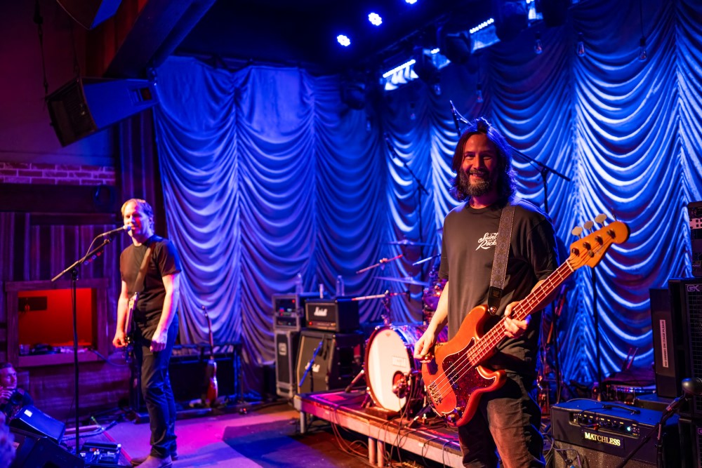 Keanu Reeves and the Dogstar band performing live on stage, with Reeves playing bass guitar alongside his bandmates at Saint Rocke